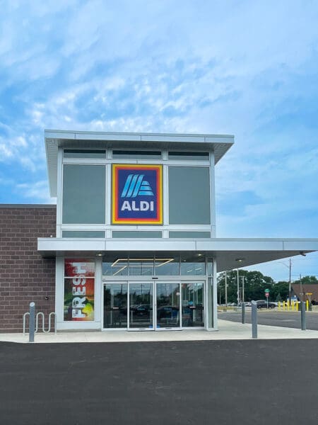 Exterior view of an ALDI store entrance under a clear sky, highlighting the brand logo.