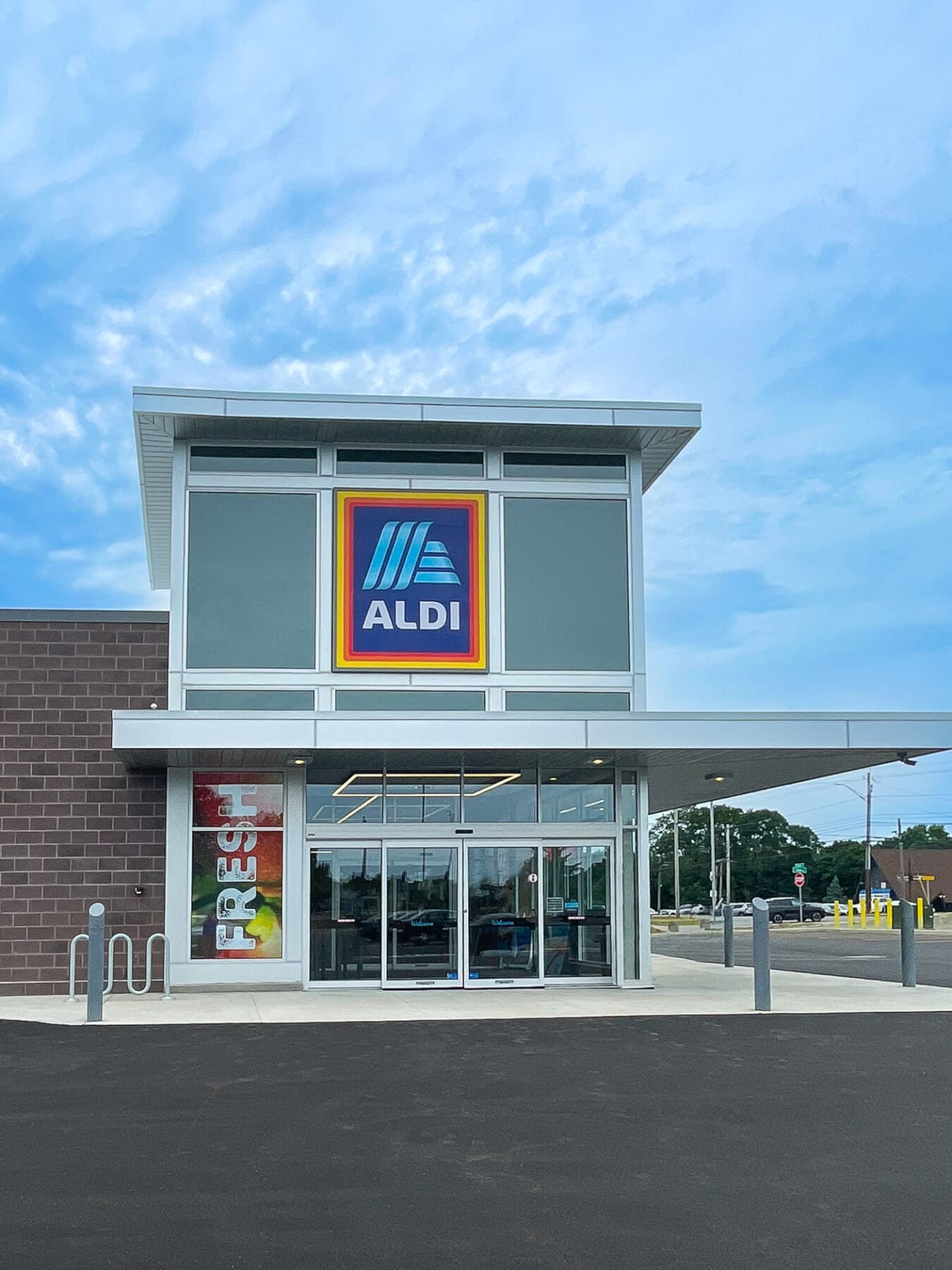 Exterior view of an ALDI store entrance under a clear sky, highlighting the brand logo.