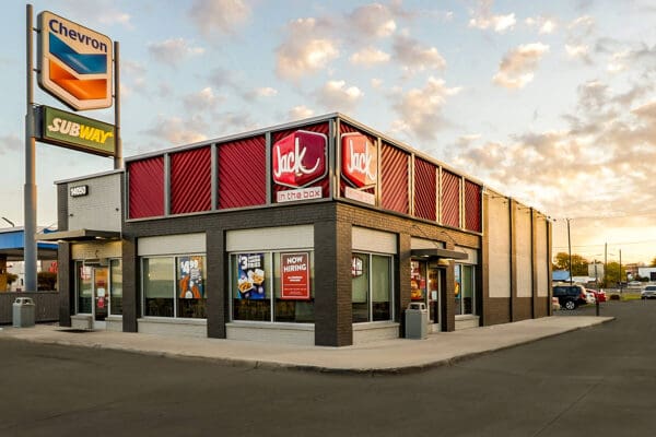 Jack in the Box fast-food restaurant at sunset, featuring “Now Hiring” sign.