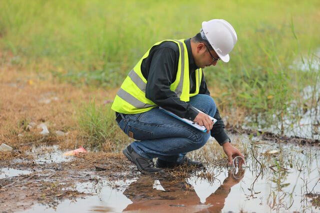 Environmental engineers work at water source to check for contam
