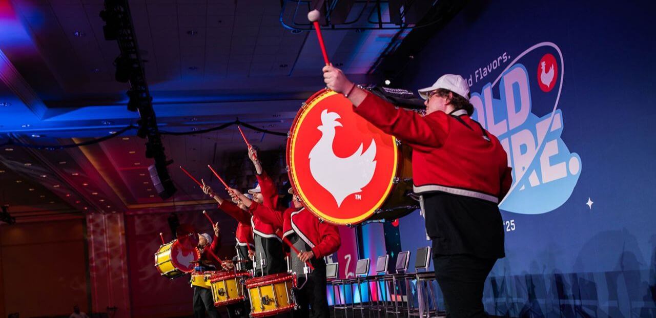 Drummers perform in vibrant outfits at a KFC event, highlighting the brand's energetic spirit and world flavors theme.