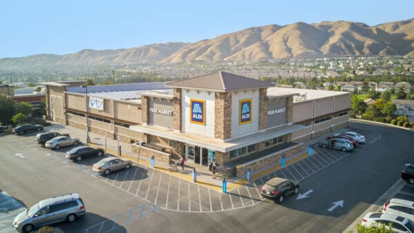 ALDI supermarket exterior in sunny mountain area with parking.