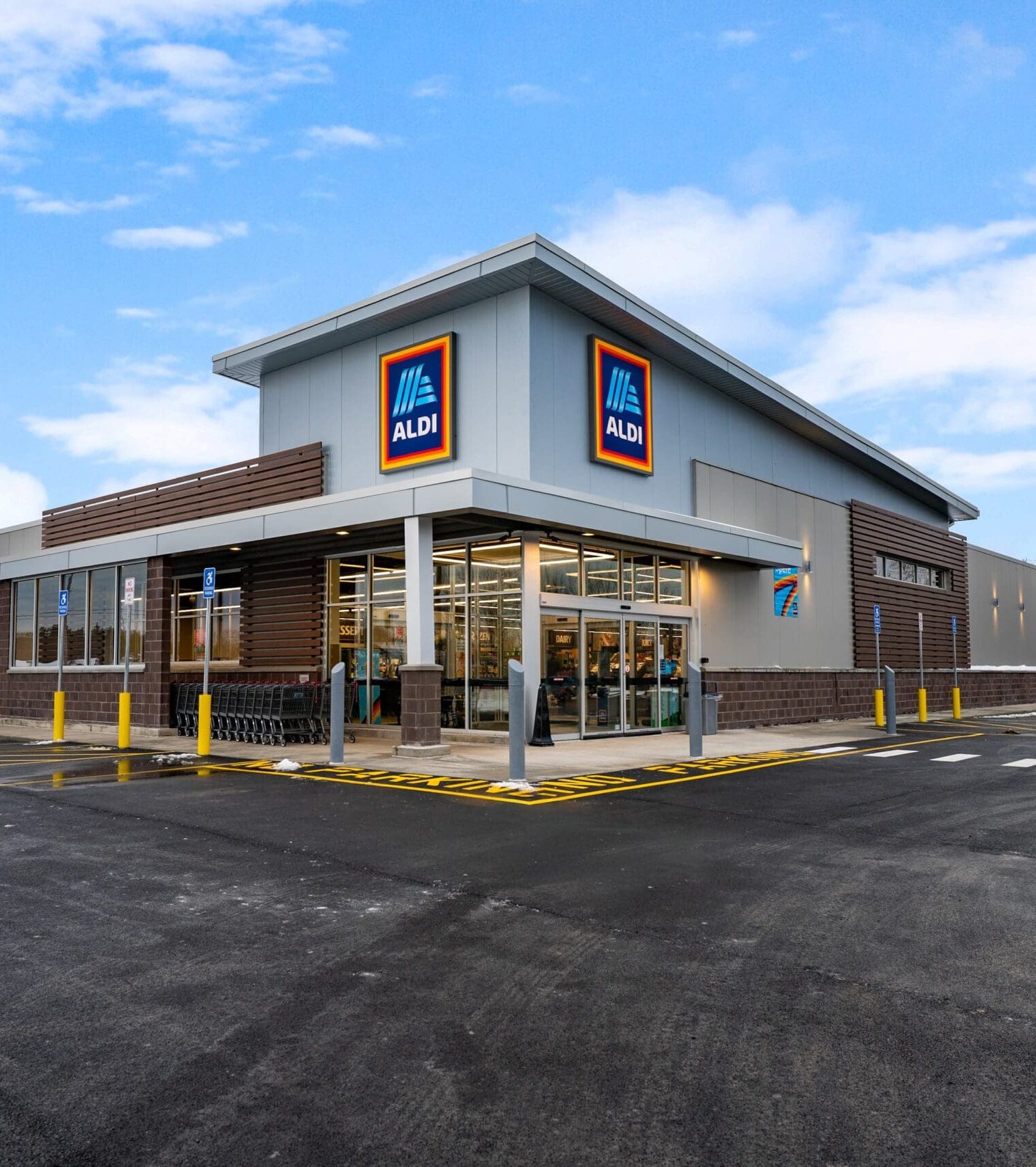 Modern Aldi supermarket exterior with parking lot on a clear day.