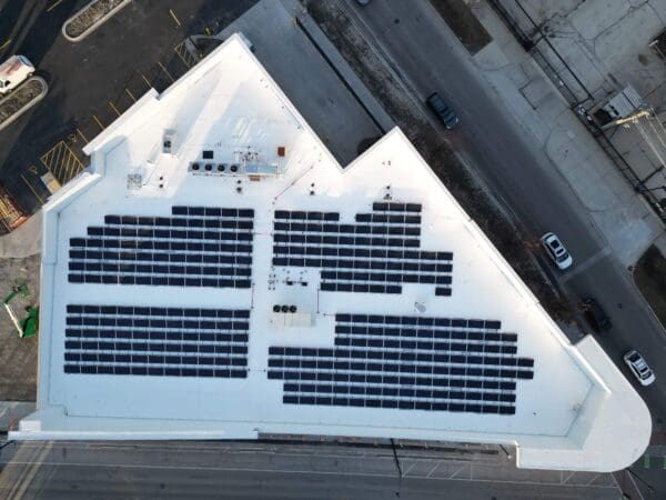 Rooftop solar panels on a triangular building in an urban area, highlighting sustainable energy solutions.