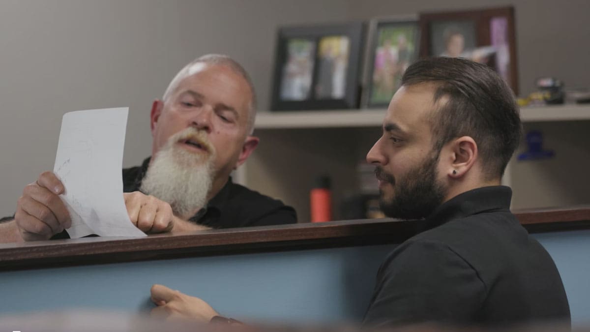 Two colleagues discussing a document at their office desk, fostering teamwork and collaboration.