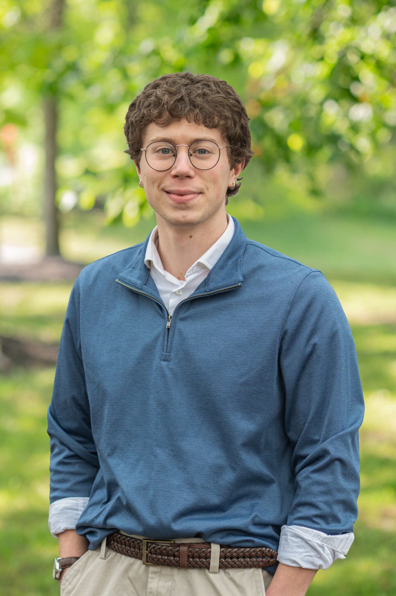 Young man in casual attire smiling outdoors, representing [Brand Name] for authenticity and style.