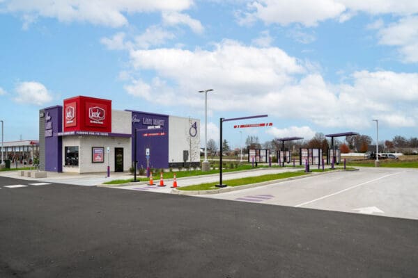 Late-night drive-thru at Jack in the Box, showcasing spacious parking and clear signage under a bright sky.