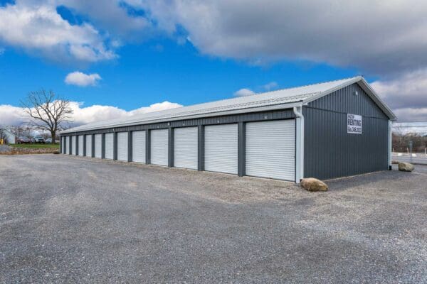 Rows of grey storage units under a blue sky, now available for rent. Call for details.