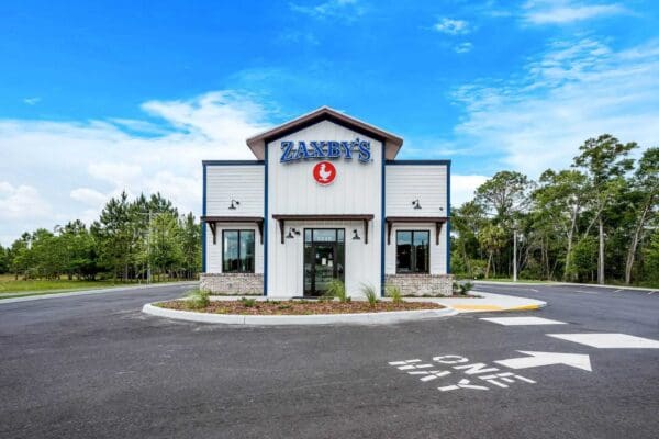 Zaxby's restaurant exterior with clear blue sky, highlighting the entrance and logo prominently. Family dining experience.