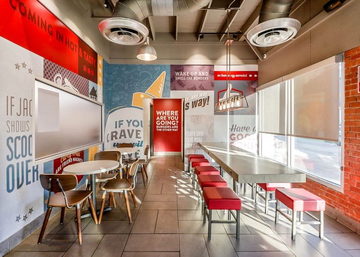 Modern fast-food restaurant interior featuring colorful, motivational wall art and sleek seating area.