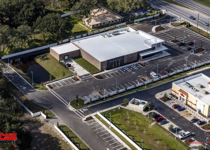 Aerial view of commercial parking lot and building construction by Case Contracting, highlighting new development area.