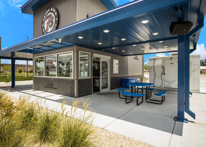 Outdoor view of Seven Brew Coffee drive-thru with seating area and modern design.