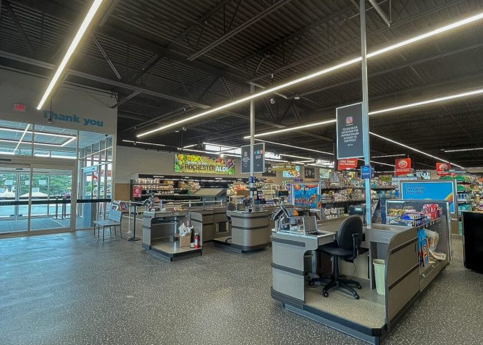 Modern grocery store checkout area with empty registers and bright lighting.
