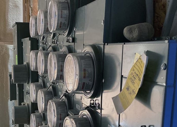 Electrical meters on a wall inside a utility room, showcasing electricity management systems.