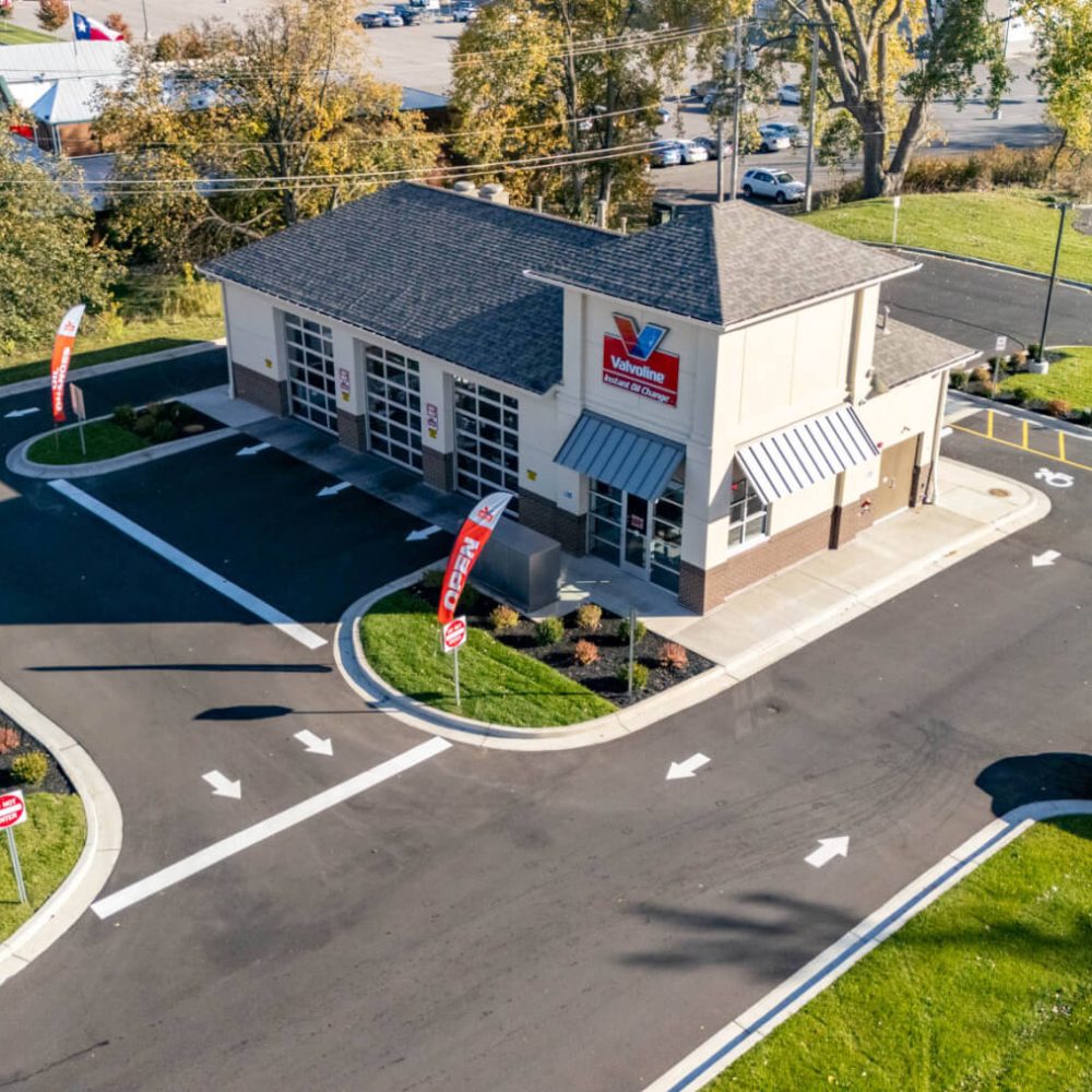 Aerial view of a Valvoline Instant Oil Change service center with clear drive-through lanes and surrounding parking area.