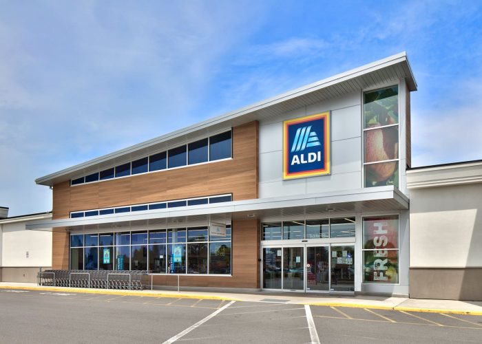 Aldi storefront on a sunny day, featuring the brand's logo and entrance.