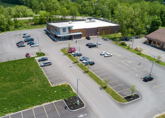 Aerial view of a spacious Aldi parking lot, showcasing ample space and greenery.
