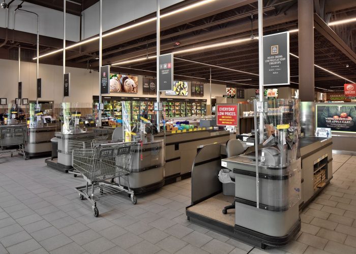 Modern grocery checkout area with shopping carts, promoting low prices at a supermarket.