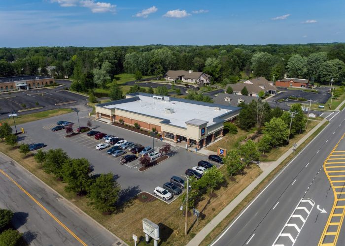 Aerial view of grocery store with full parking lot on a sunny day.