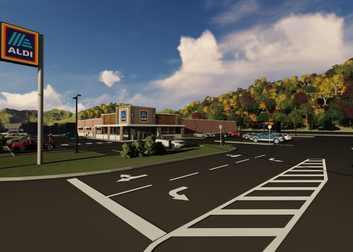 Exterior view of an Aldi supermarket with a spacious parking lot and scenic autumn backdrop.