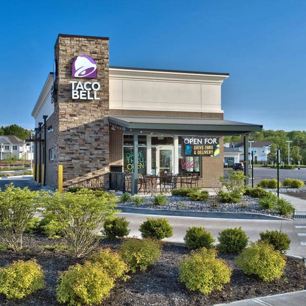 Taco Bell restaurant exterior showcasing drive-thru and delivery options.