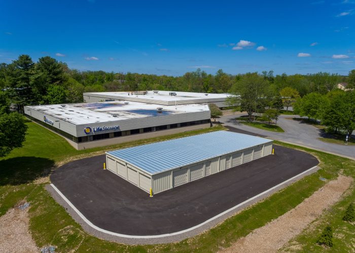 Life Storage facility in a green setting with clear blue skies, offering ample storage space for all your needs.