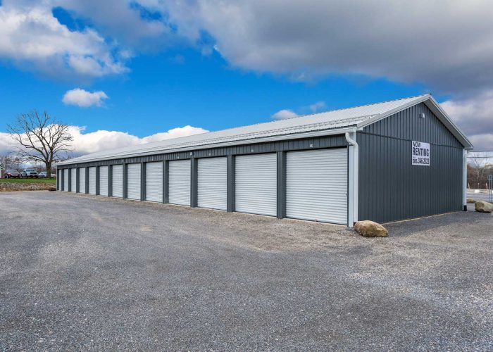 Rows of grey storage units under a blue sky, now available for rent. Call for details.