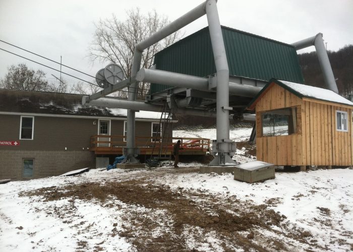 Ski lift base station at snowy resort, with lodge and patrol cabin nearby. Perfect for winter adventures.