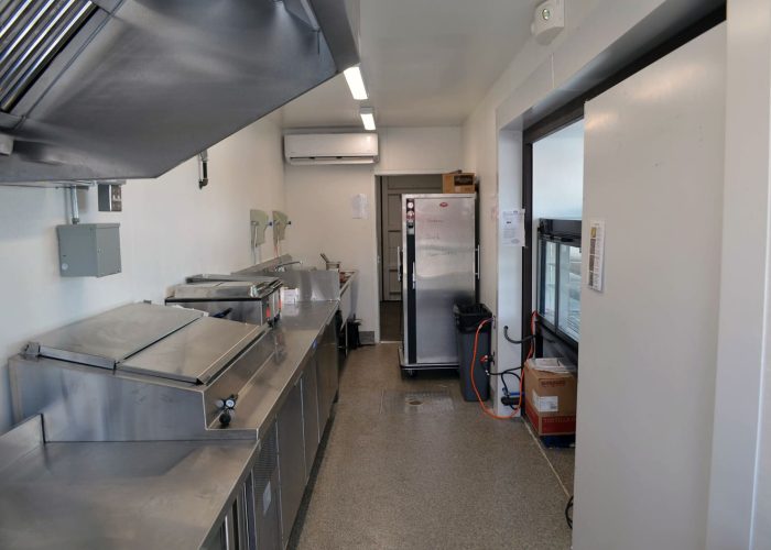 Modern commercial kitchen with stainless steel appliances and storage units. Ideal for food service operations.