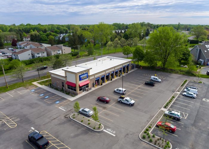 Aerial view of Monro Auto Service shop with parking lot and surrounding greenery.