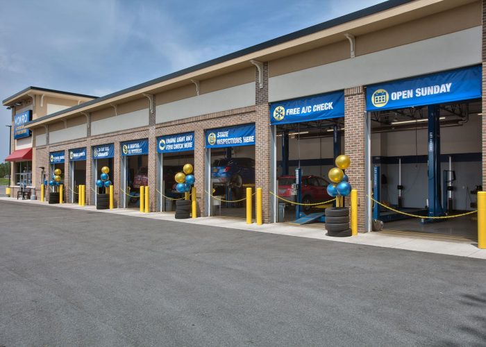 Auto service center offering free A/C checks, open Sunday, with car bays and colorful balloons promoting special services.