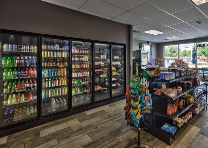 Convenience store interior showcasing stocked beverage coolers and snack shelves for quick shopping.