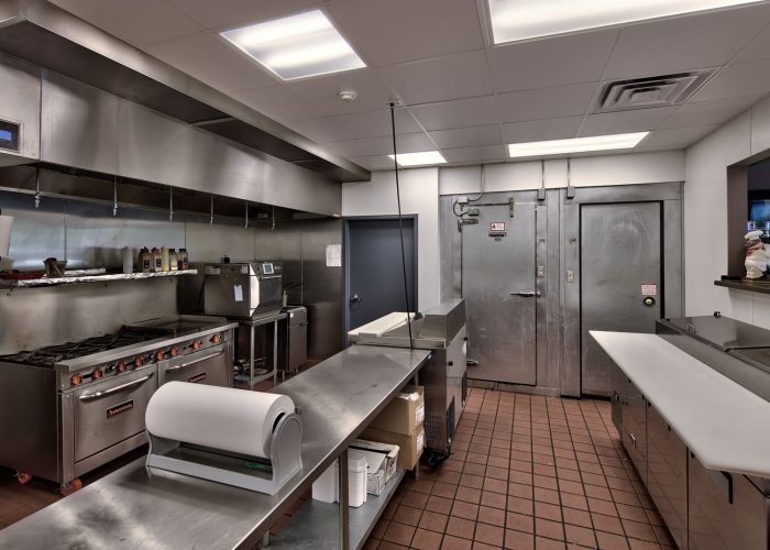 Professional commercial kitchen with stainless steel equipment and industrial appliances, ideal for restaurant operations.