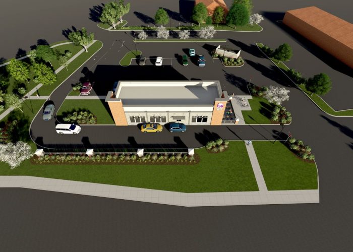 Aerial view of Taco Bell drive-thru layout with parked cars and landscaped surroundings.