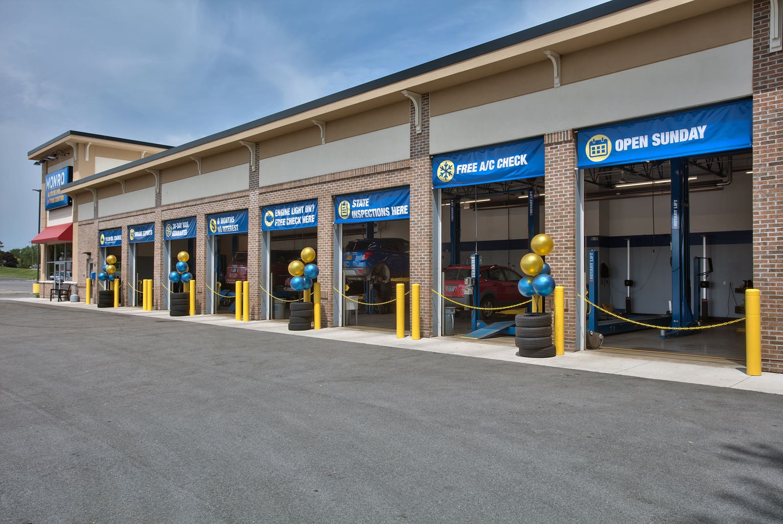 Auto service center offering free A/C checks and state inspections with colorful balloons outside.