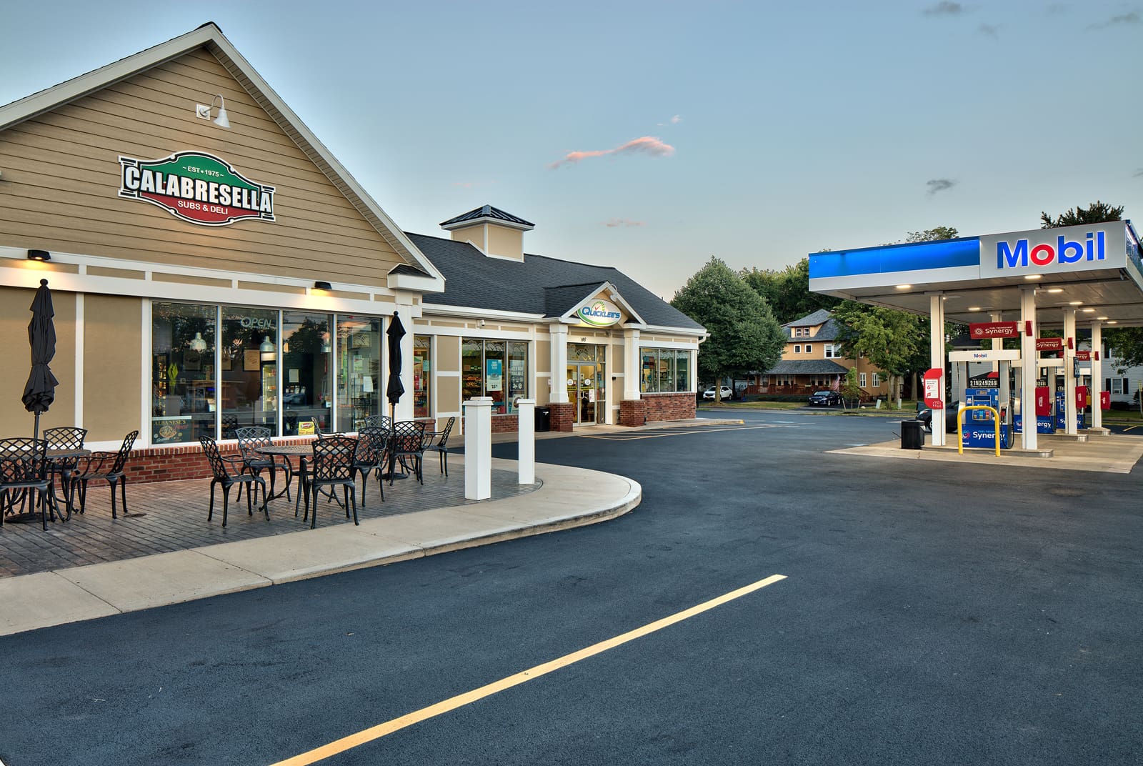 Calabresella Subs & Deli and Mobil gas station with outdoor seating on a sunny day.